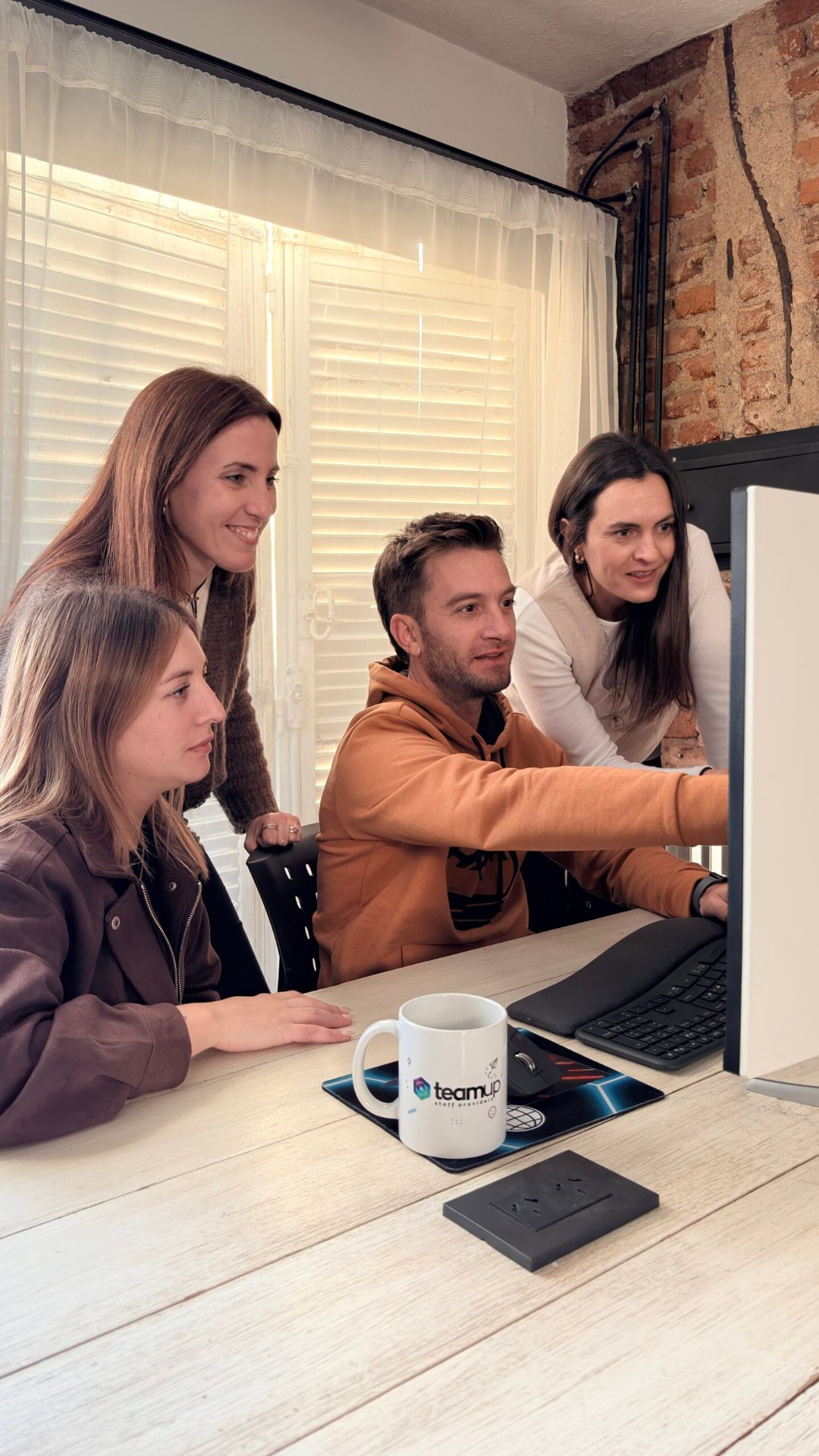 TeamUp team collaborating around a PC
